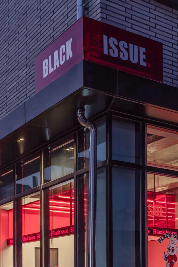 그레이 벽돌과 레드 네온의 코너 카페 외관